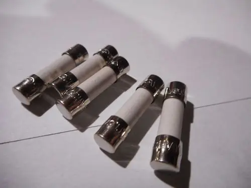 Fünf Feinsicherungen mit Metallenden auf einer hellen Oberfläche, abgebildet in einem schlichten Arrangement. Hersteller: Remeha.